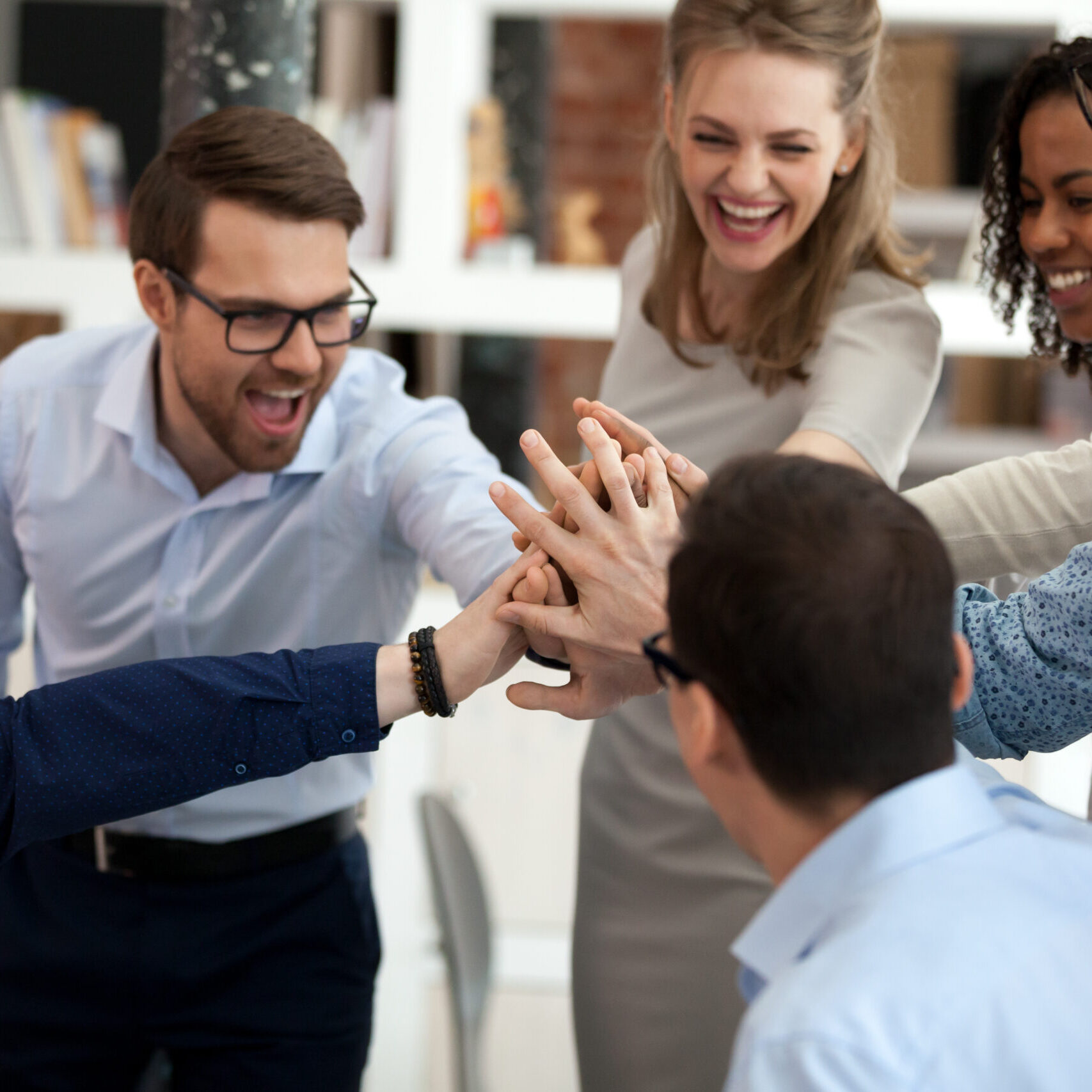Excited motivated multi-ethnic team people give high five, happy diverse office employees executive group celebrate corporate success, sharing victory, engaged in unity support teambuilding concept